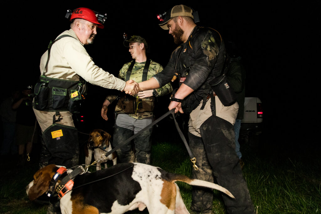 Competition coon hunters shaking hands at a hunt.