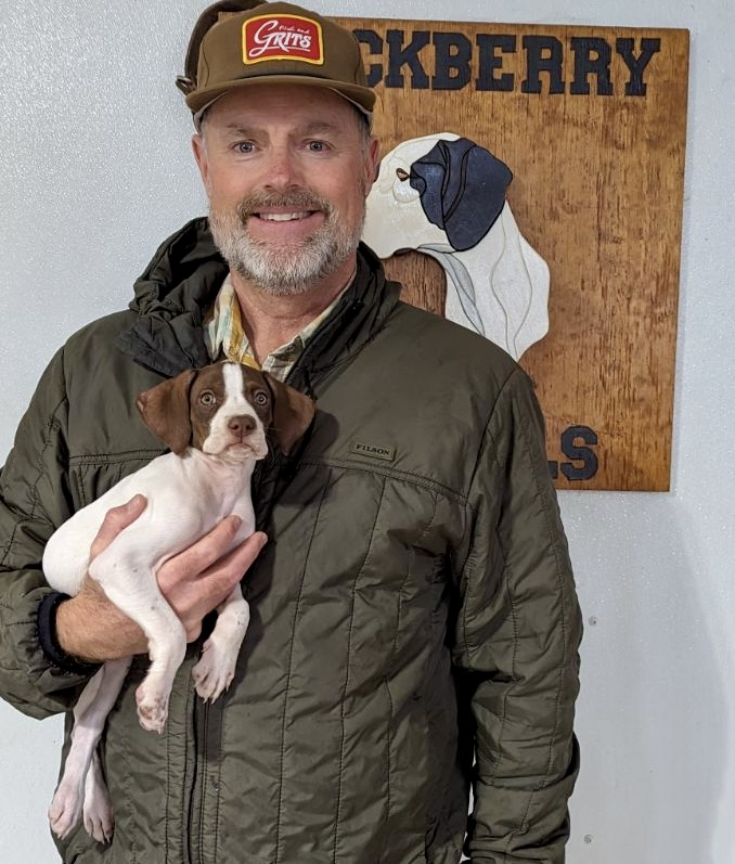 Shawn K. Wayment, bird dog doc holding an english pointer puppy.