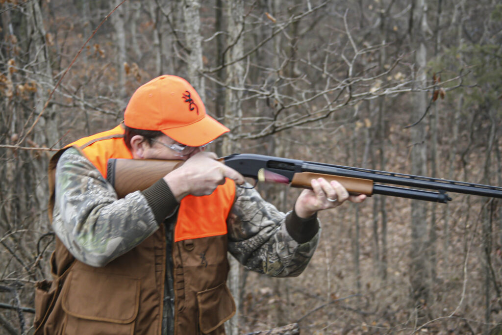 A deer hunter shooting a slide action pump shotgun Remington 870.
