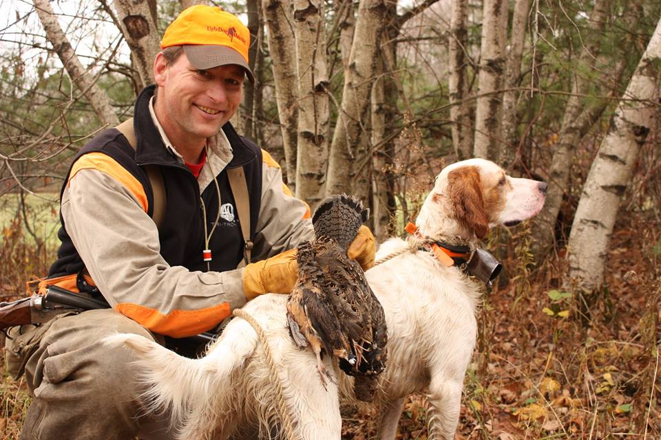 An upland bird hunter with an English setter and a ruffed grouse.