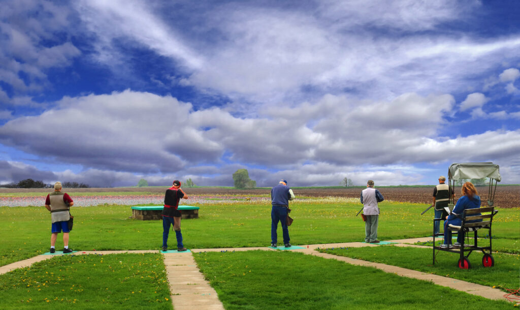 Several trap shooters shooting a round of trap with a bunker trap house.